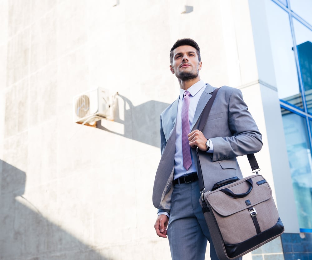 Portrait of a handsome businessman standing outdoors near office buildingち